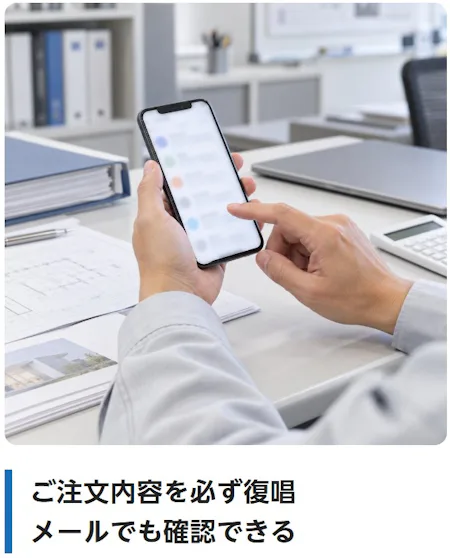 ご注文内容を必ず復唱メールでも確認できる（事務所のデスクで、スマートフォンでお見積のメールを確認している様子）