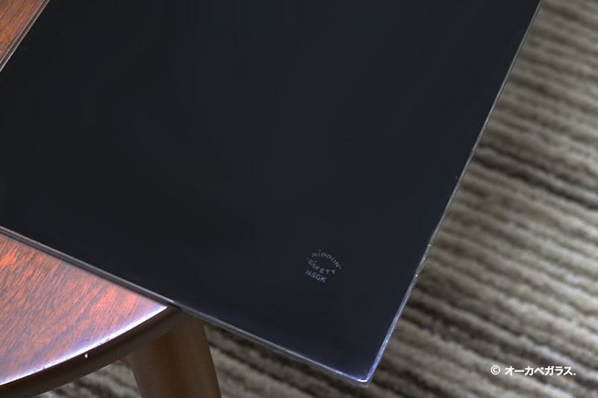 傷の付いたテーブルに「セラミックプリントガラス ブラック(プレーン)」置いた様子